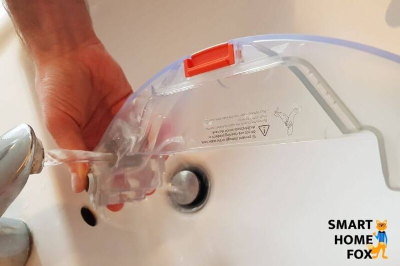 Der Wassertank eines Saugroboters wird mit Wasser befüllt